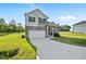 Charming two-story home with stone accents, a covered porch, an attached garage, and a well-manicured lawn at 482 Olivia Crossing Ct, Four Oaks, NC 27524