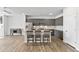 Modern kitchen featuring an island with seating, grey cabinets, and stainless steel appliances in a well-lit space at 482 Olivia Crossing Ct, Four Oaks, NC 27524