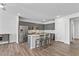 Modern kitchen featuring an island with seating, grey cabinets, and stainless steel appliances in a well-lit space at 482 Olivia Crossing Ct, Four Oaks, NC 27524