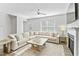 Spacious living room featuring a large, comfortable sectional sofa, fireplace with TV, and airy natural light at 482 Olivia Crossing Ct, Four Oaks, NC 27524