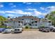 Exterior view of a multi-story apartment building with parking lot, balconies, and well maintained landscaping at 4907 Hollenden Dr # 106, Raleigh, NC 27616