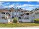 Exterior angle shot of a multi-story apartment building with private balconies and mature shrubs at 4907 Hollenden Dr # 106, Raleigh, NC 27616