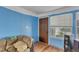 Bright living room with brown door, blue painted walls, wood floors and natural light at 4907 Hollenden Dr # 106, Raleigh, NC 27616