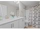Bathroom featuring double sinks, white cabinets, framed mirror, and a shower/tub combo at 5 Cinnamon Teal Way, Youngsville, NC 27596