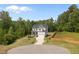 Two story home with green grass and a winding driveway surrounded by trees and sky at 5 Cinnamon Teal Way, Youngsville, NC 27596