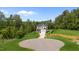 Two-story home with a manicured lawn, surrounded by a border of mature trees at 5 Cinnamon Teal Way, Youngsville, NC 27596
