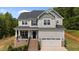 Inviting two-story home boasts a brick foundation, attached garage, and manicured landscaping at 5 Cinnamon Teal Way, Youngsville, NC 27596