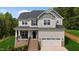 Charming two-story home featuring a covered porch, attached garage, and meticulously landscaped front yard at 5 Cinnamon Teal Way, Youngsville, NC 27596