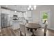 Eat-in kitchen showcases granite counters, stainless appliances, white cabinets, and a modern light fixture at 5 Cinnamon Teal Way, Youngsville, NC 27596