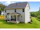 Expansive backyard featuring lush green lawn, two-story home with a covered patio, and wooded backdrop at 5 Cinnamon Teal Way, Youngsville, NC 27596