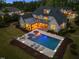 Aerial view of backyard featuring an inground pool, tanning ledge, and covered patio for entertaining in luxury at 5125 Avalaire Oaks Dr, Raleigh, NC 27614