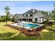 A backyard oasis features a modern pool, lounge area, and covered porch for ultimate relaxation at 5125 Avalaire Oaks Dr, Raleigh, NC 27614