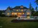 Twilight view of backyard showcases inground pool, lush landscaping, manicured lawn, and covered outdoor entertaining area at 5125 Avalaire Oaks Dr, Raleigh, NC 27614