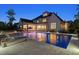 Stunning backyard features a large pool with lounge chairs, umbrellas and covered outdoor living space at twilight at 5125 Avalaire Oaks Dr, Raleigh, NC 27614