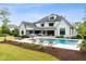 Expansive backyard showcases an inground pool, tanning ledges, lush landscaping, and a patio for outdoor gatherings at 5125 Avalaire Oaks Dr, Raleigh, NC 27614