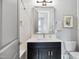 Cozy bathroom with a marble tiled shower, decorative mirror, and modern fixtures at 5125 Avalaire Oaks Dr, Raleigh, NC 27614
