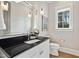 Powder room featuring modern fixtures, stylish wallpaper, and a sleek black countertop at 5125 Avalaire Oaks Dr, Raleigh, NC 27614