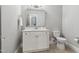 Bright half bath with a white vanity, square mirror, and elegant fixtures at 5125 Avalaire Oaks Dr, Raleigh, NC 27614