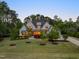Charming two-story home with lush front lawn, mature trees, and inviting entryway illuminated at twilight at 5125 Avalaire Oaks Dr, Raleigh, NC 27614