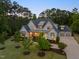 Expansive two-story home with well-manicured lawn, mature trees, and driveway leading to a three-car garage at 5125 Avalaire Oaks Dr, Raleigh, NC 27614