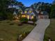 Grand two-story home with lush landscaping, mature trees, long driveway and attached three-car garage at 5125 Avalaire Oaks Dr, Raleigh, NC 27614