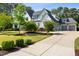 Charming two-story home with a lush front yard, mature trees, and a long, spacious driveway leading to the garage at 5125 Avalaire Oaks Dr, Raleigh, NC 27614