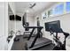 Well-equipped home gym featuring treadmill, rower, and wall-mounted displays at 5125 Avalaire Oaks Dr, Raleigh, NC 27614