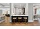 Contemporary kitchen breakfast bar features three bar stools and hardwood flooring throughout at 5125 Avalaire Oaks Dr, Raleigh, NC 27614