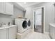 Bright laundry room with modern washer and dryer, sink, and ample counter space at 5125 Avalaire Oaks Dr, Raleigh, NC 27614