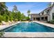 Backyard pool with tanning ledges, water features and lounge chairs, plus views of the well-manicured lawn at 5125 Avalaire Oaks Dr, Raleigh, NC 27614