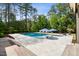 Inviting backyard pool featuring water fountains, tanning ledges, umbrellas and lounge chairs, perfect for outdoor relaxation at 5125 Avalaire Oaks Dr, Raleigh, NC 27614