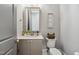 Charming powder room with a stylish vanity, granite countertop, and classic toilet at 5125 Avalaire Oaks Dr, Raleigh, NC 27614