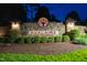Nighttime view of the illuminated 'AVALAIRE' stone entrance sign surrounded by lush greenery and inviting ambiance at 5125 Avalaire Oaks Dr, Raleigh, NC 27614