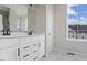 Well-lit bathroom showcasing a double vanity with modern fixtures, sleek white cabinets, and a large mirror at 5906 Dunzo Dr, Raleigh, NC 27617
