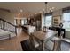 Open-concept dining area next to the kitchen with a stylish table and a view into the living room and staircase at 5906 Dunzo Dr, Raleigh, NC 27617