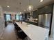 Modern kitchen featuring a spacious island with seating, stainless steel appliances, and views into the adjacent living room at 5906 Dunzo Dr, Raleigh, NC 27617