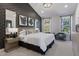 Serene main bedroom featuring a patterned accent wall, a luxurious bed, soft lighting, and a cozy seating area near windows at 5906 Dunzo Dr, Raleigh, NC 27617