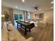 An open recreation room with a large sectional sofa, shuffleboard table, and sliding glass doors at 5906 Dunzo Dr, Raleigh, NC 27617