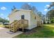 White siding with newly installed wooden deck and steps leading to the backyard on a sunny day at 623 Lincoln Dr, Kenly, NC 27542
