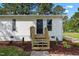 A clean, well-maintained entrance is showcased with vinyl siding and new wooden steps leading up to the front door at 623 Lincoln Dr, Kenly, NC 27542