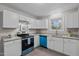 Bright kitchen featuring white cabinets, granite countertops, and stainless steel appliances with blue accents at 623 Lincoln Dr, Kenly, NC 27542