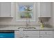 Bright kitchen featuring white cabinets, granite countertops, and stainless steel appliances with blue accents at 623 Lincoln Dr, Kenly, NC 27542