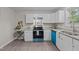 Bright kitchen featuring white cabinets, granite countertops, and stainless steel appliances with blue accents at 623 Lincoln Dr, Kenly, NC 27542