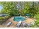 Community pool with chairs and umbrellas surrounded by trees, and a view of the parking lot in the background at 700 Martin Luther King Jr Blvd # A6, Chapel Hill, NC 27514