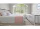 Bedroom featuring a large window, neutral decor, crib, and a comfortable armchair at 708 Mill Pointe Way, Elon, NC 27244