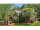 Aerial side view of a red brick home with mature trees at 708 Mill Pointe Way, Elon, NC 27244
