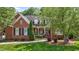Charming two-story brick home with manicured lawn and lush landscaping, including mature trees at 708 Mill Pointe Way, Elon, NC 27244