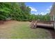 Spacious backyard featuring a wooden deck and lush green lawn, framed by mature trees and a fence at 8004 Mill Bluff Ct, Raleigh, NC 27616