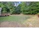 Expansive backyard with a wooden deck and a combination of green grass and natural ground cover at 8004 Mill Bluff Ct, Raleigh, NC 27616