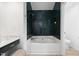 Updated bathroom with dark tile surround on soaking tub and separate toilet area at 8004 Mill Bluff Ct, Raleigh, NC 27616